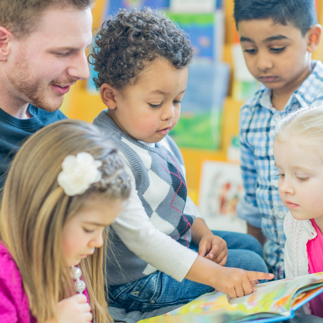 Group of young children being read a story.